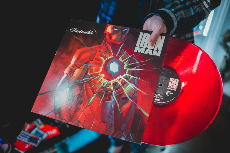 a close up of a person holding a red colored vinyl