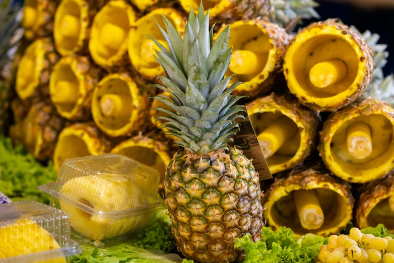 pineapples and bananas are on the table, beside other fruits