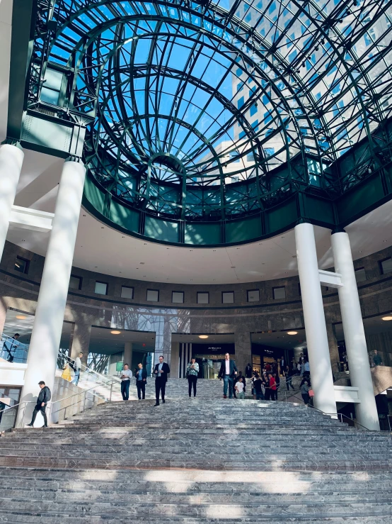 people are walking up and down steps to the atrium