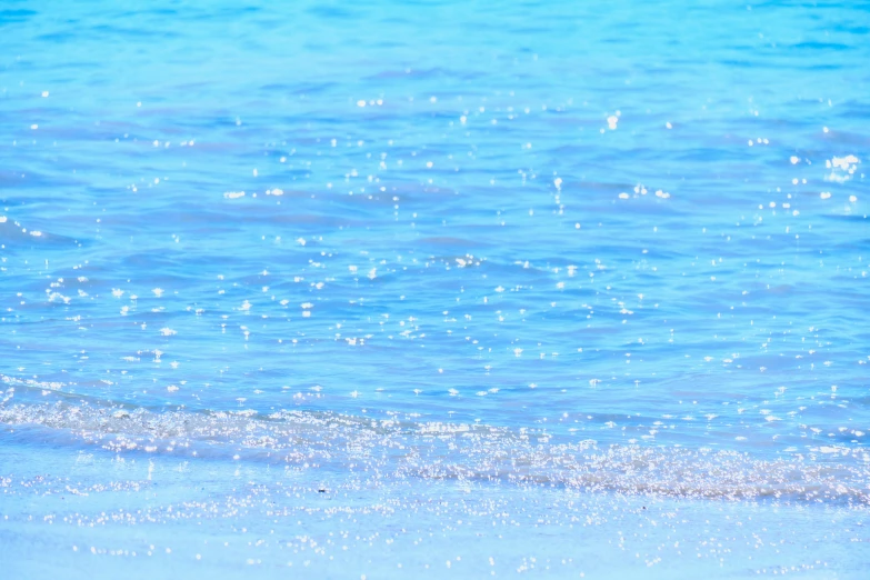 blue ocean waves on a white sandy beach