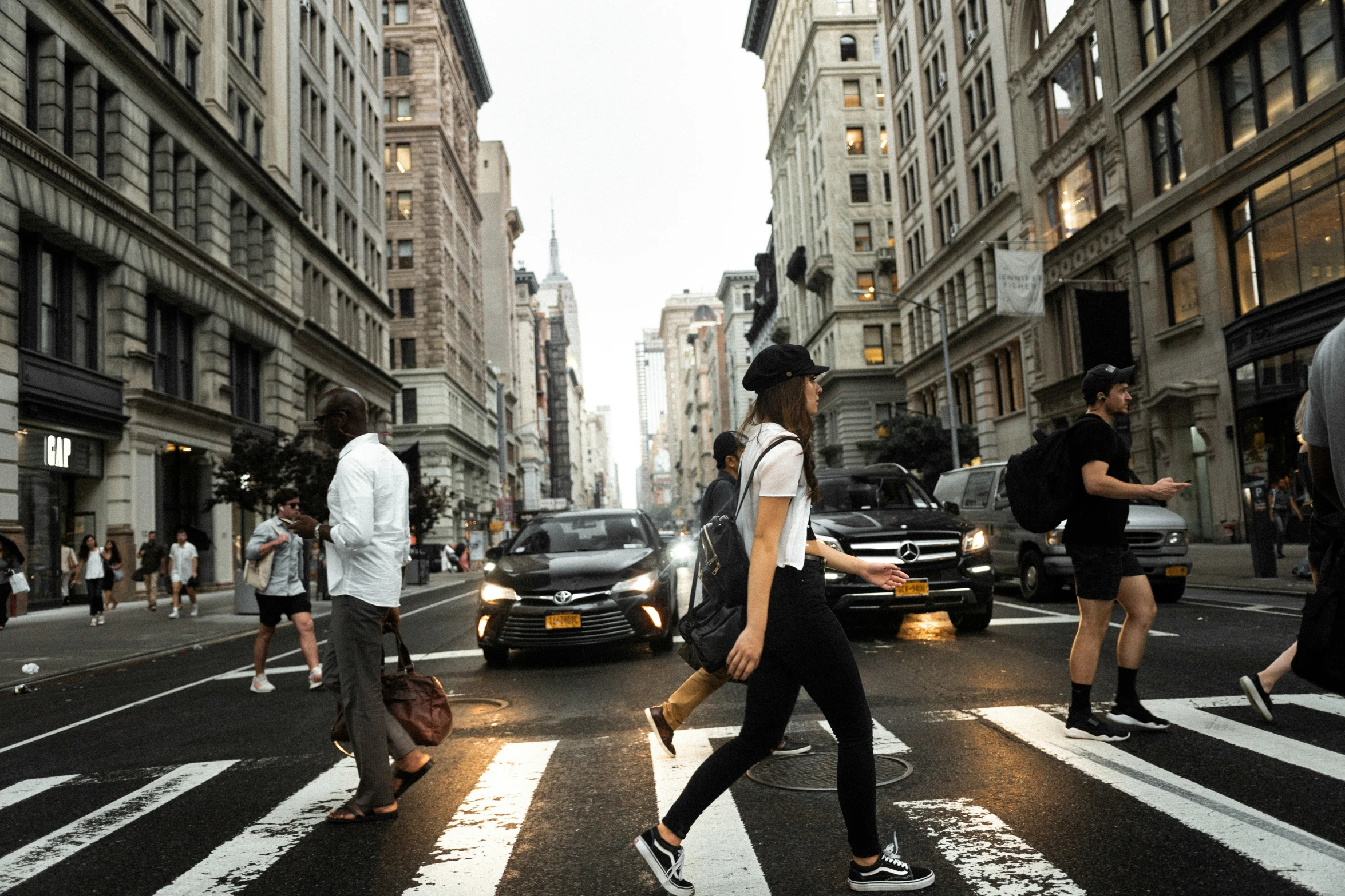 pedestrians walk across an intersection in the city