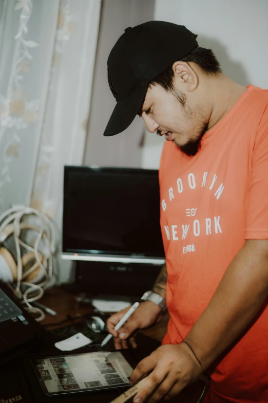 a man looks down at his computer as he takes notes