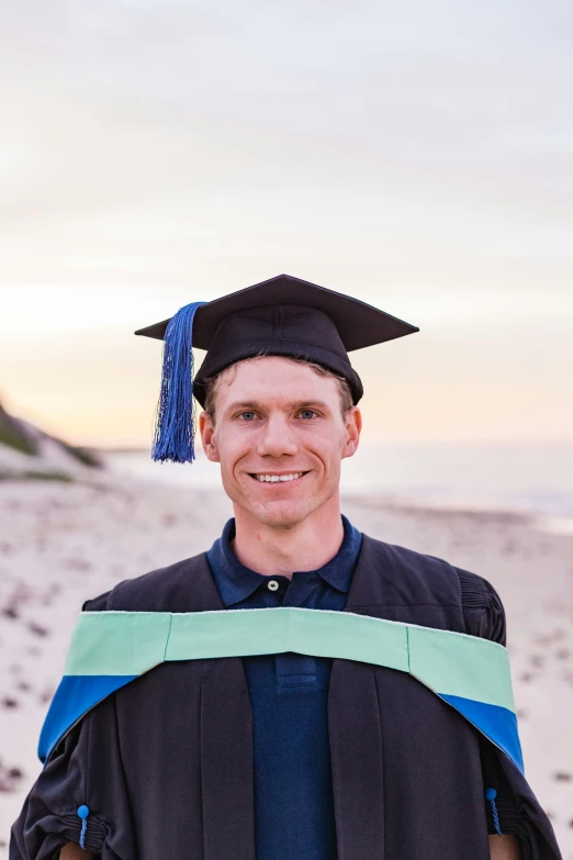 a graduate is standing with his cap and gown dd