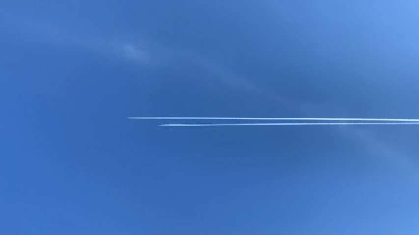 a jet flies in the air as a vapor trail begins