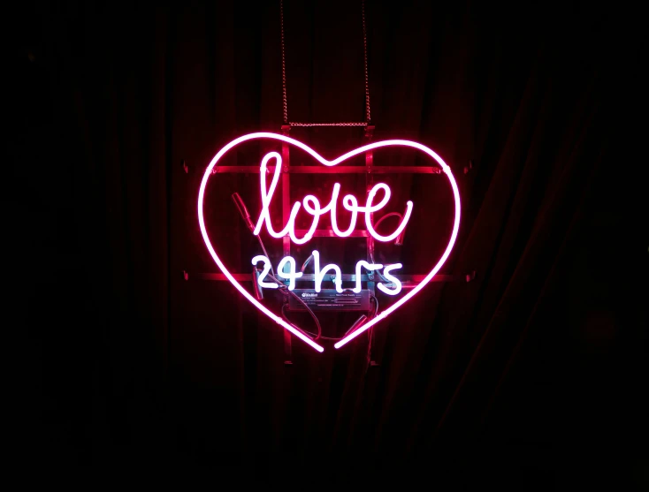 a large red neon sign with a love 24hrs sign