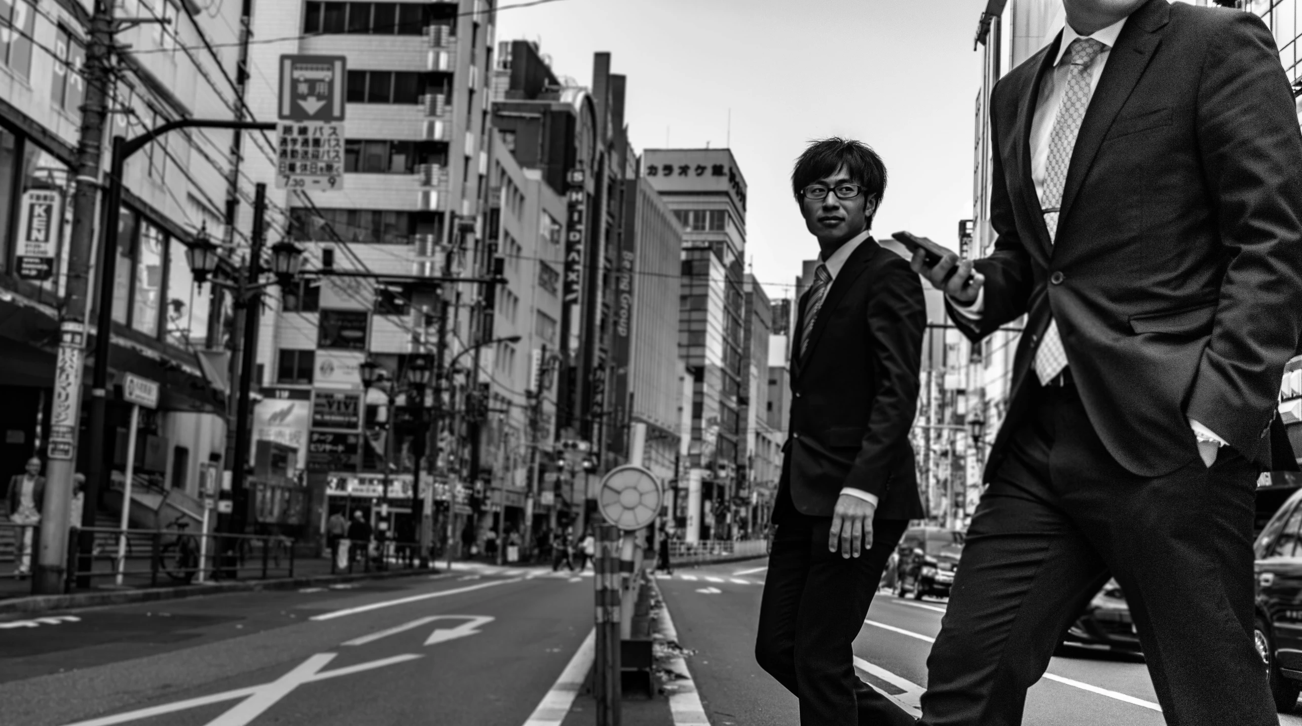 a couple of men in business suits crossing a street