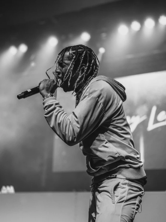 a man with dread locks singing into a microphone