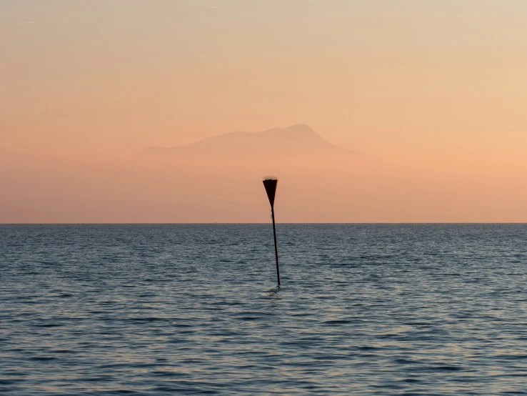 an image of a large body of water with a tall pole in the middle of it