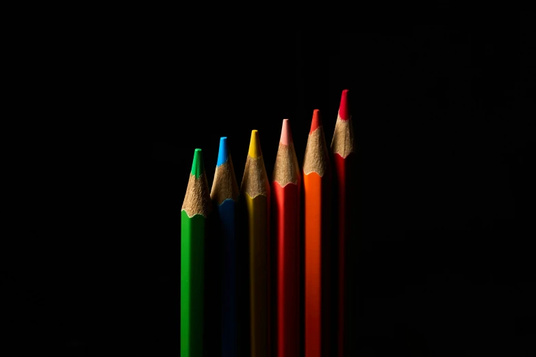 the back and front sides of four colored pencils