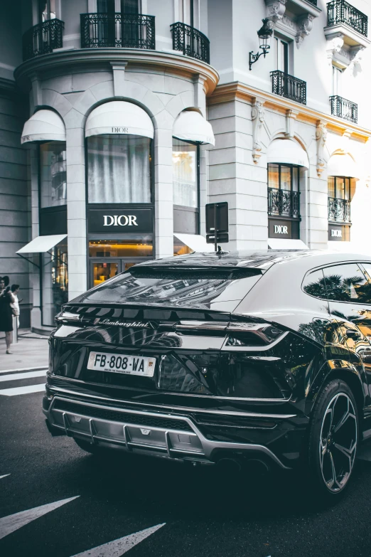 black sport car parked on street next to a building