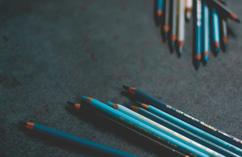 several blue pencils lying on top of a table