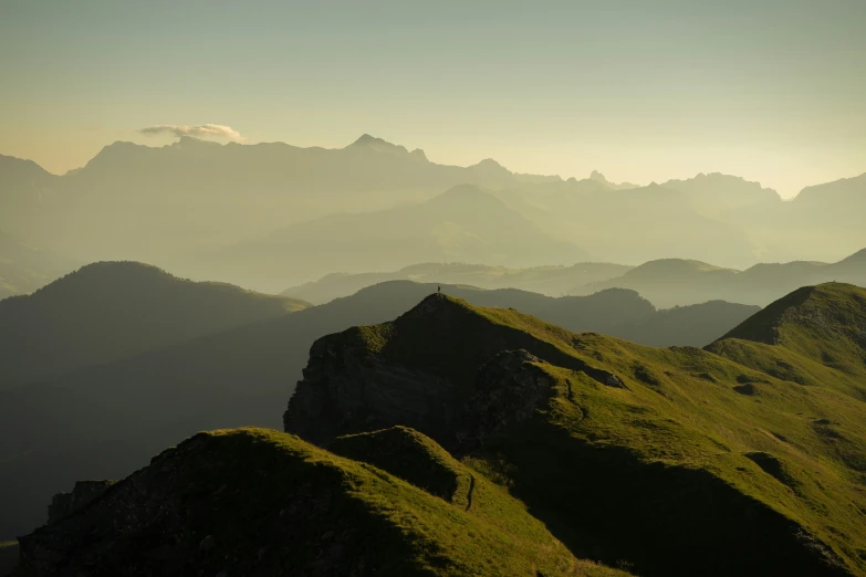 mountains in the foreground, with a distant bird flying in the distance