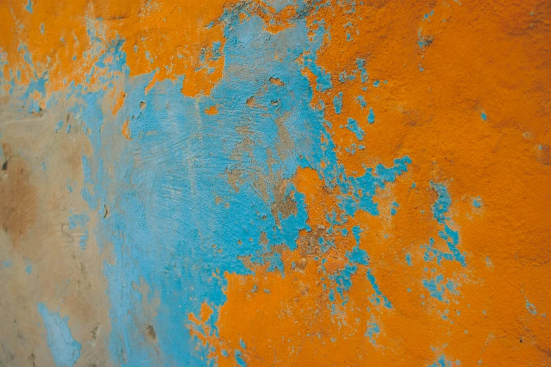 blue and orange paint covering an old wall