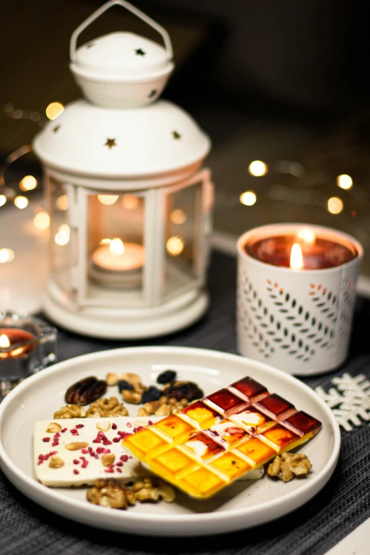 some fancy food on a plate next to candle lights