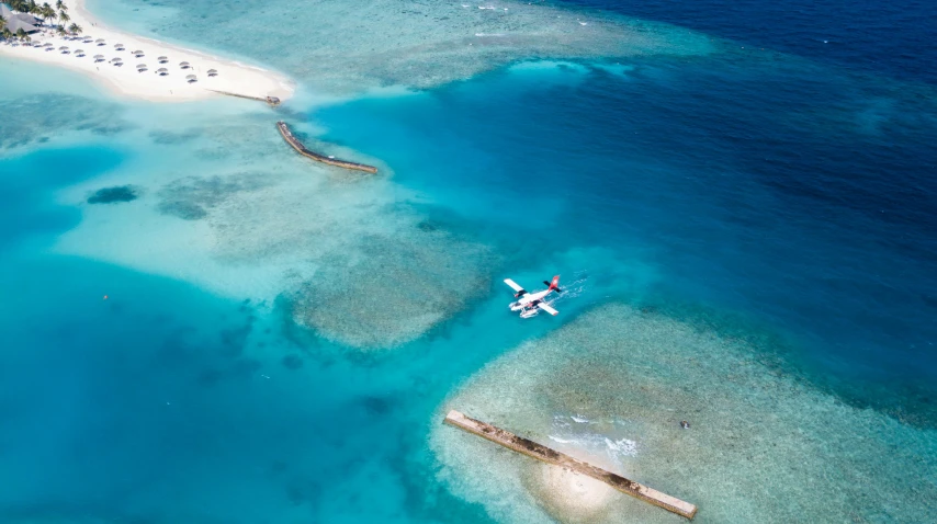 a plane is flying over some water near an island