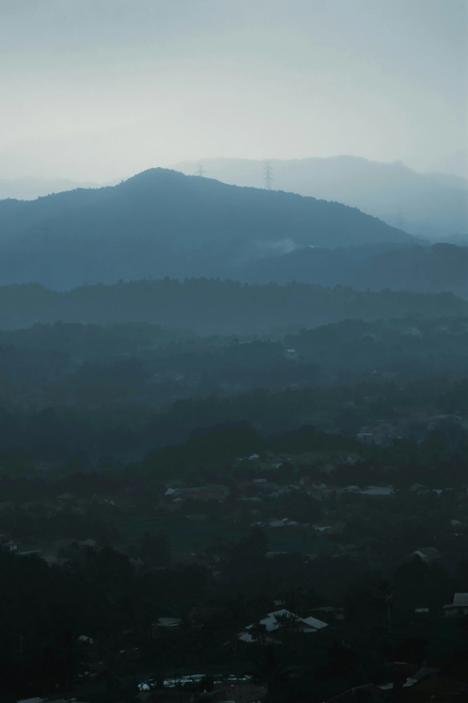 some trees mountains and clouds a city and mountains