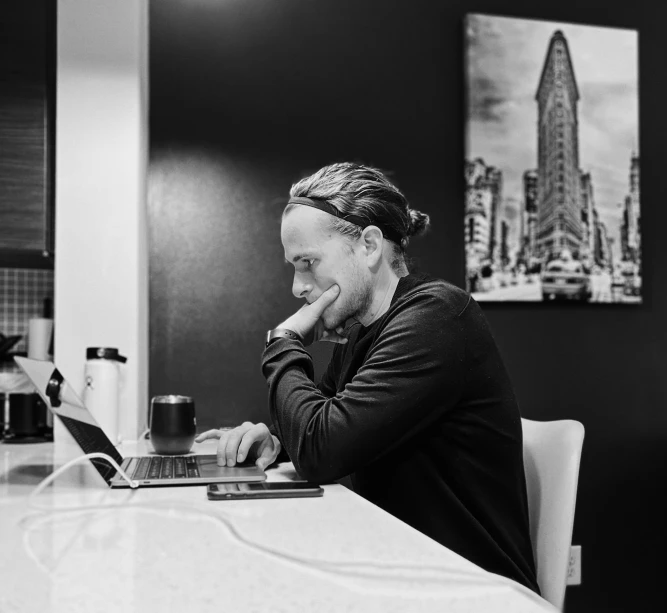 a man with dreadlocks on uses his laptop