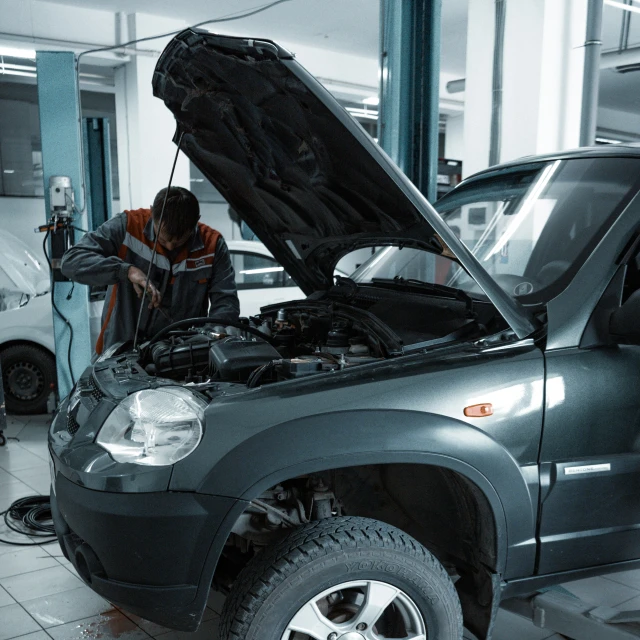 a man working on a vehicle inside of a garage