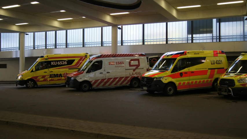 five ambulances are lined up in a parking garage