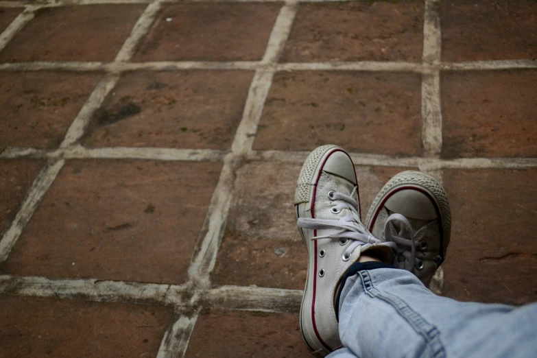 a person's foot in sneakers on a tiled floor