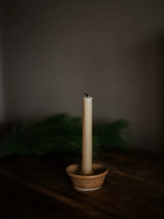 there is an orange candle sitting in a small bowl