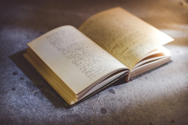 a closed book with handwriting on it laying on a floor