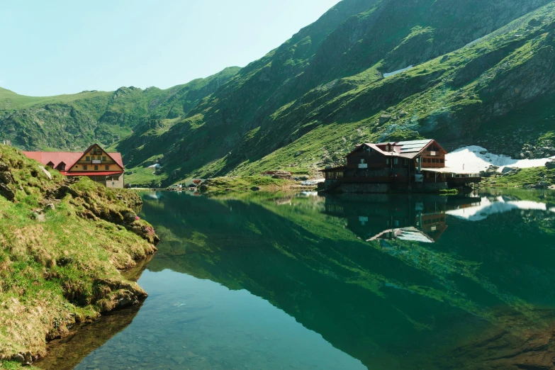 a very clear water with some small wooden houses by it