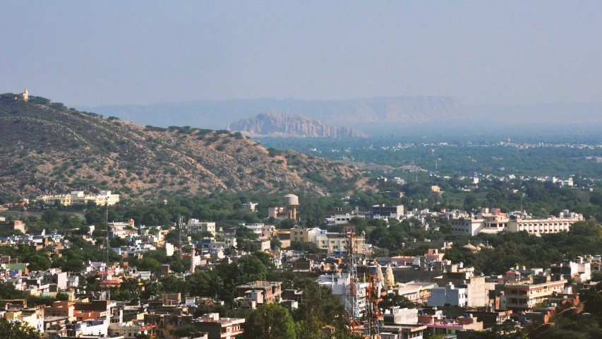 city in foreground and mountains on background with blue sky