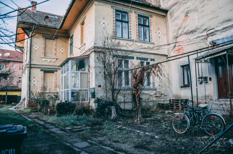 this is a dilapidated house with a bicycle in front