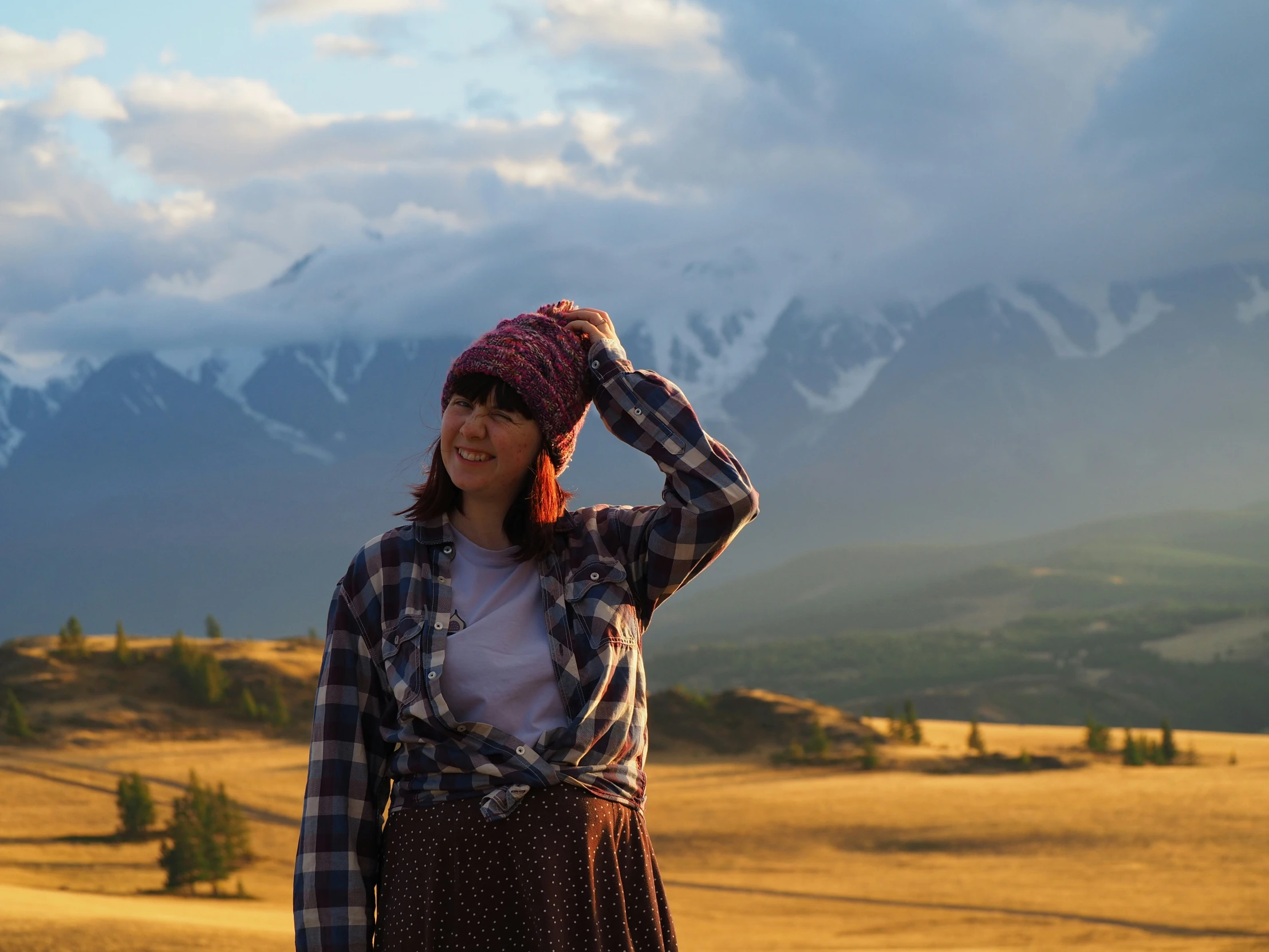 a woman in the mountains with her hat over her head