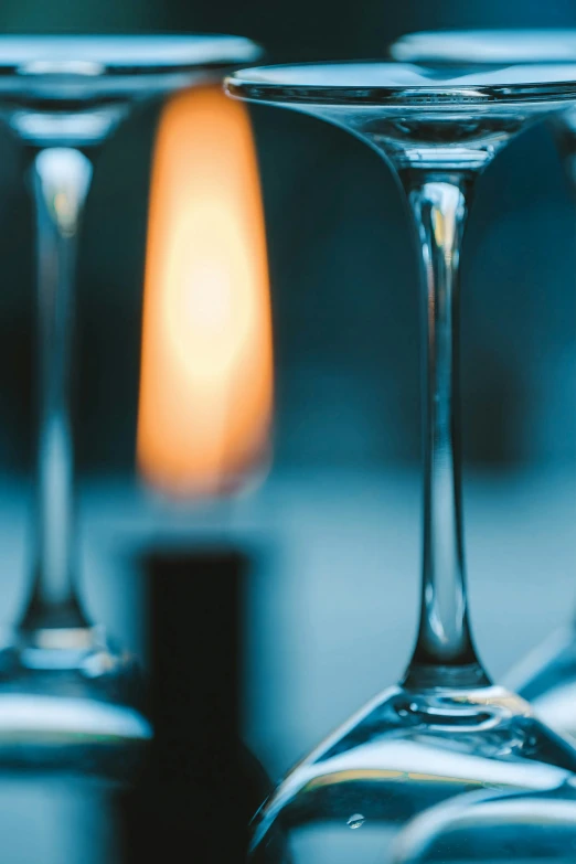 the three wine glasses have a candle in the background