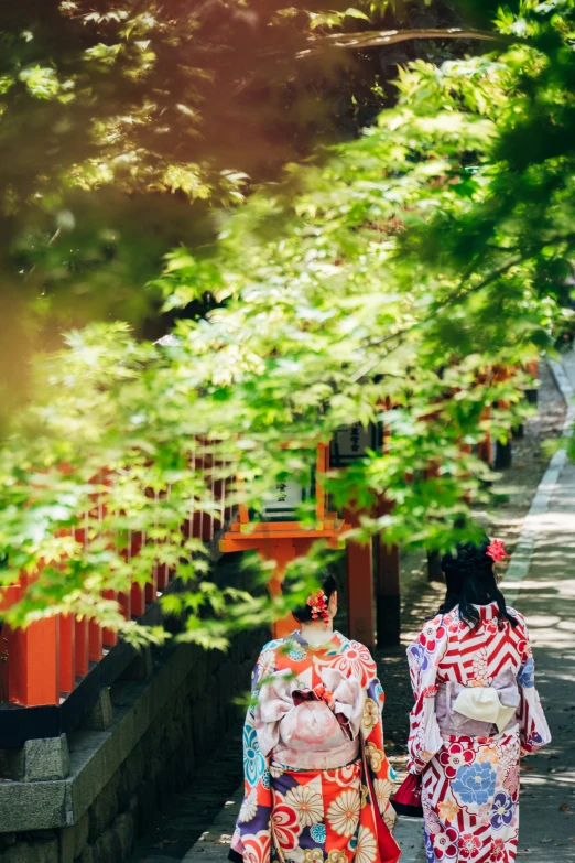 two asian women walking down a path in traditional dress