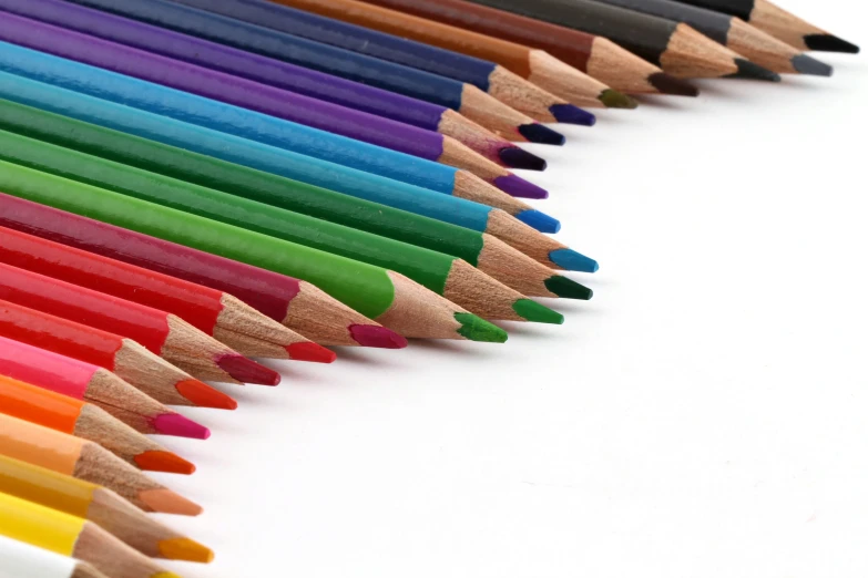 a long row of rainbow colored pencils with one pointed straight out