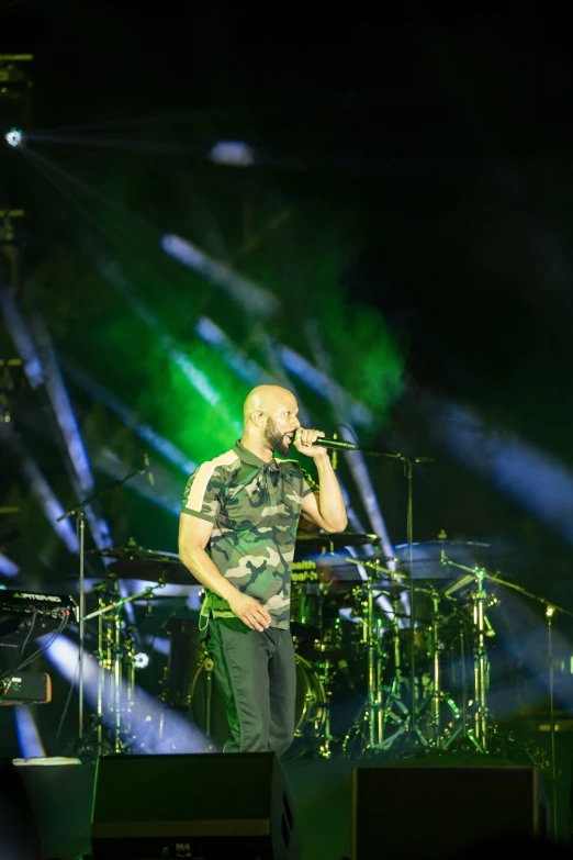 a man singing into a microphone while holding a cellphone