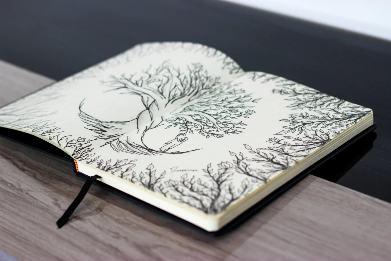 a notebook that has a tree drawn on the front cover