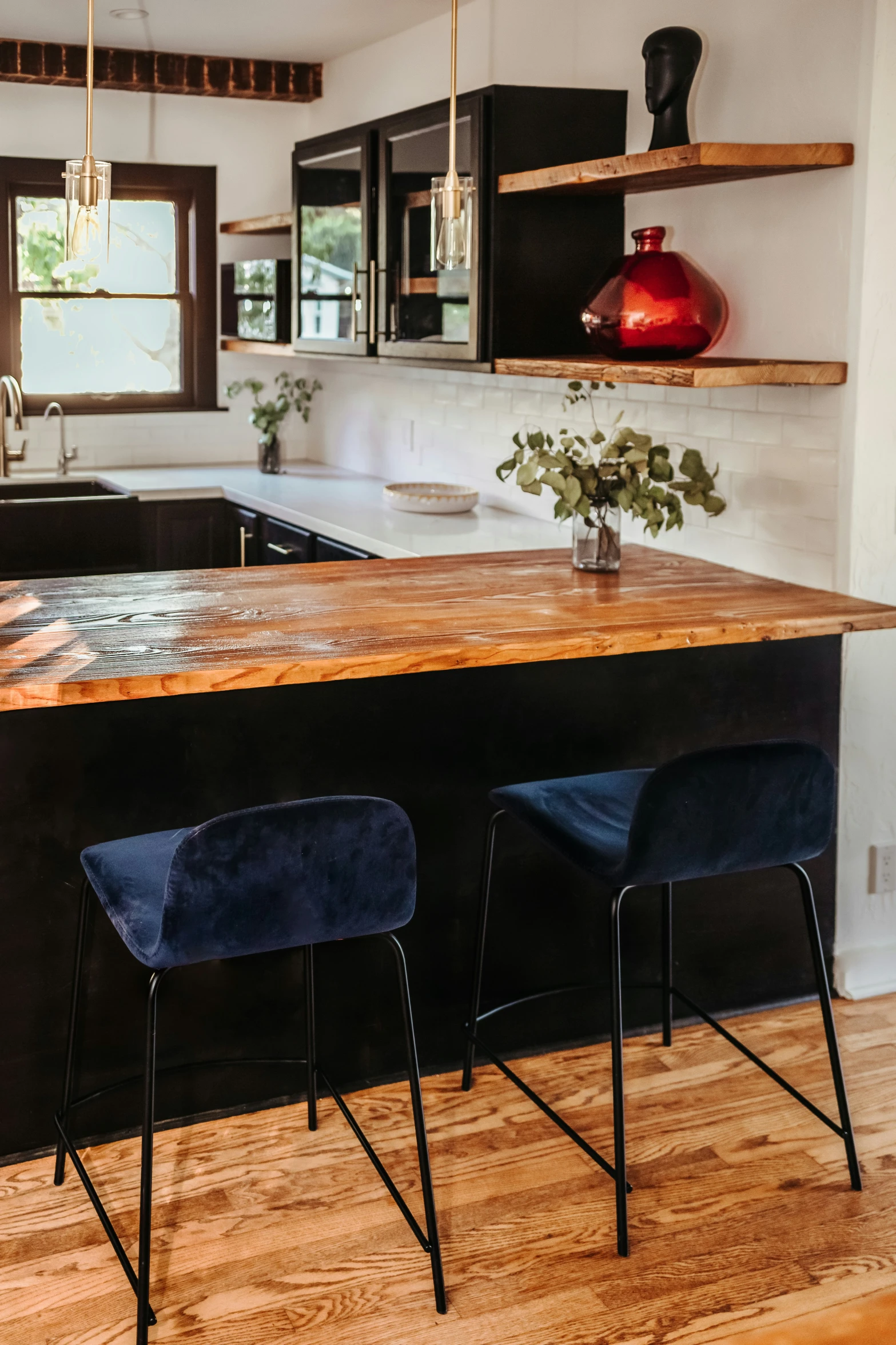 a kitchen with a bar stools, counter and oven