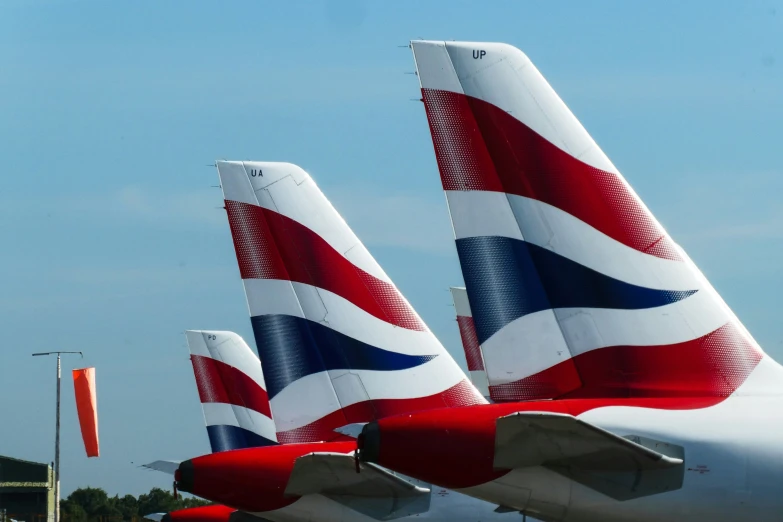 three large airliners parked in rows with flags on them