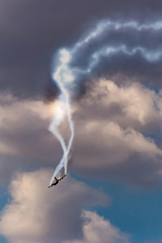 a plane in the sky that is trailing smoke