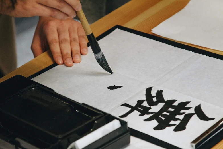 a person who is using a knife to draw on a table