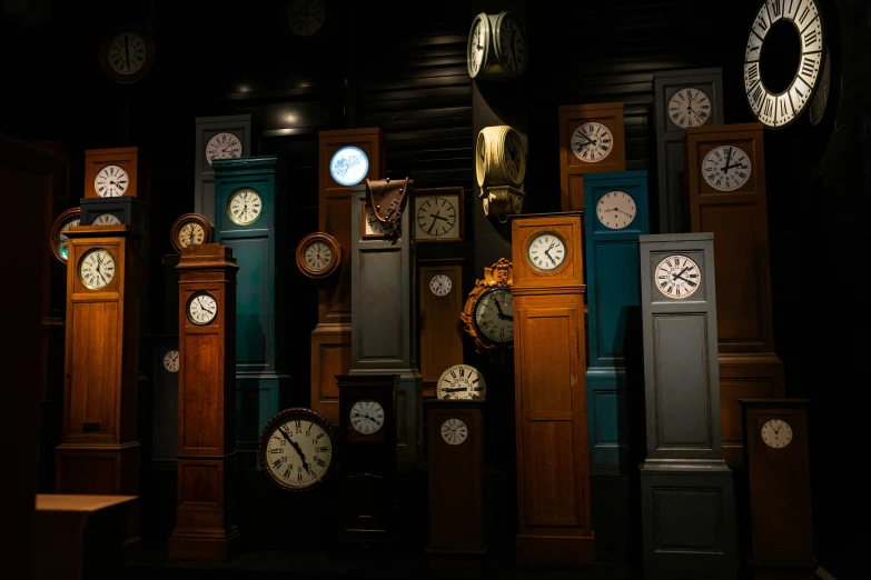 several tall clock towers in a room with different clocks