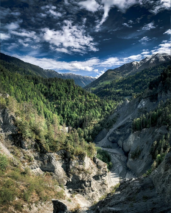 a valley with a river near by and a cloudy sky