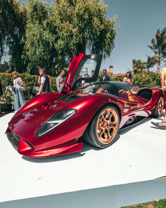 a large red sports car parked on top of a cement lot