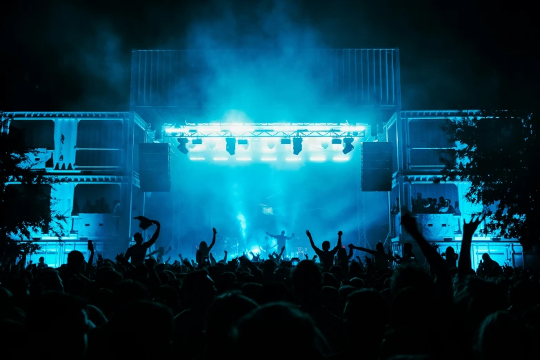 a crowd at a concert that is lit by bright lights