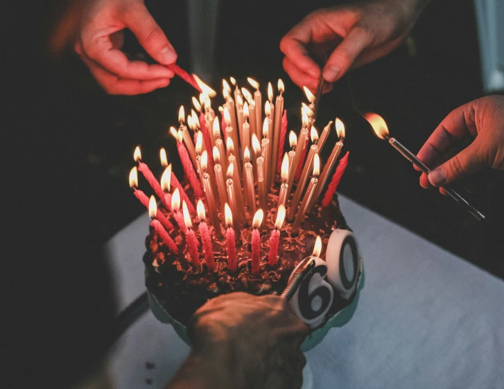 a person lighting candles in a vase full of candles