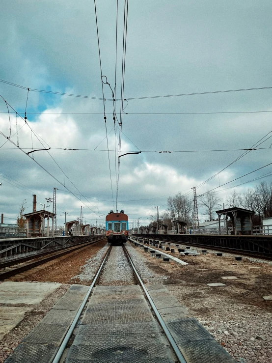 a train on a railroad tracks under cloudy skies