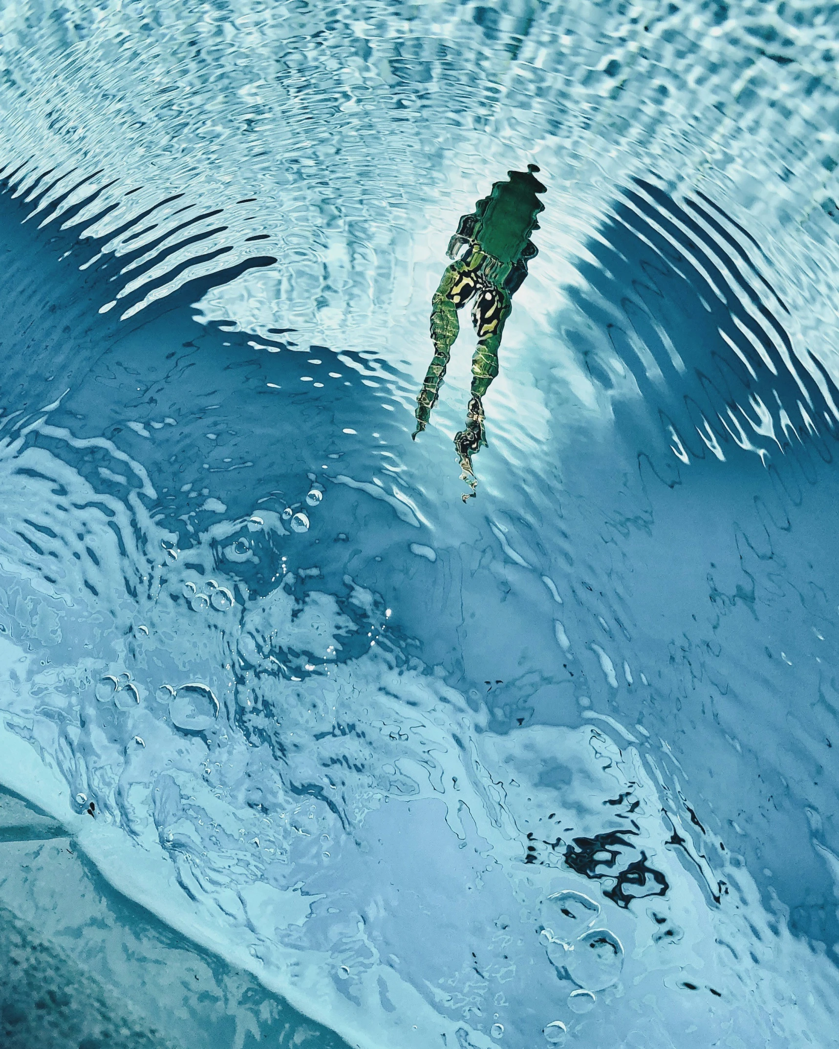 a man standing in a pool is reflected in the water