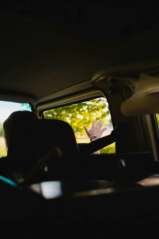 a woman sitting in a car with the passenger seat back down