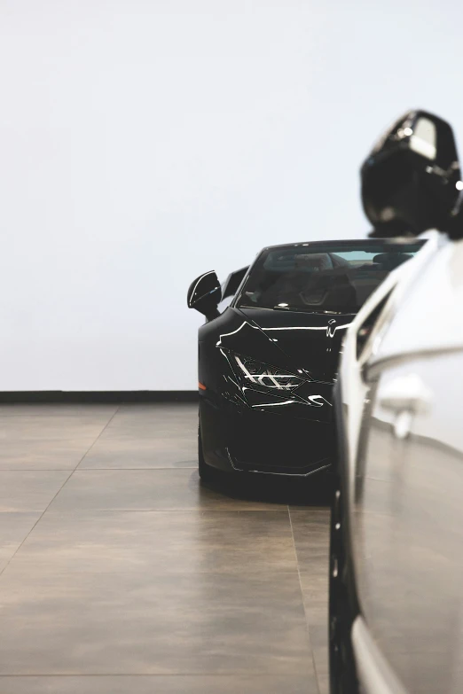 two very attractive looking black cars in a room