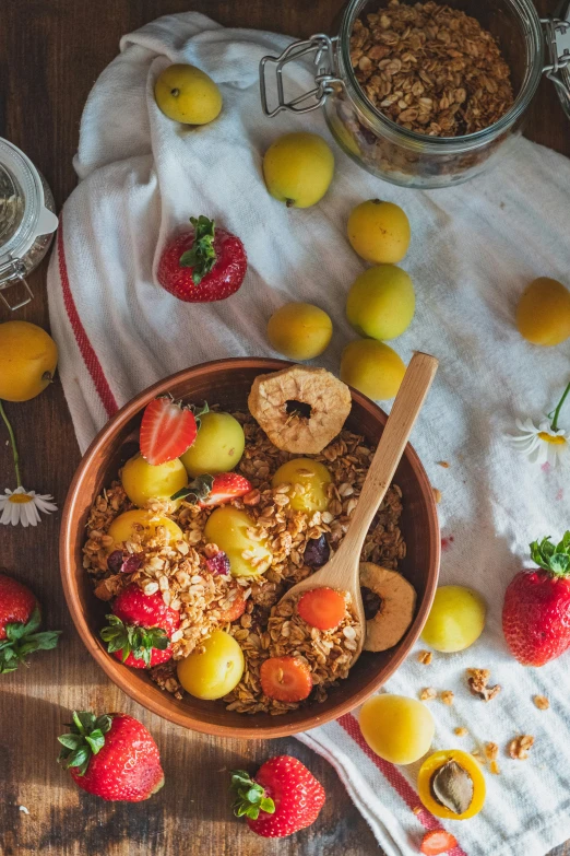 a bowl of cereal and sliced fruit sits on a table