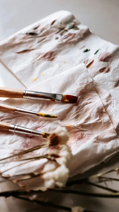 a pair of paintbrushes resting on top of a piece of paper